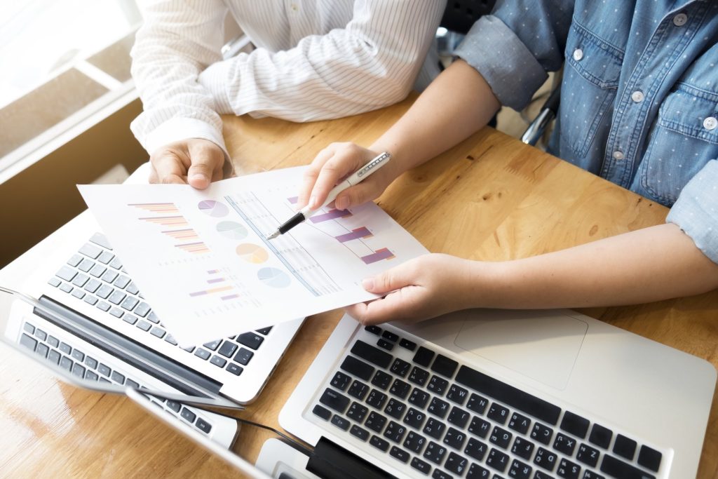 Dos personas analizando los gráficos para calcular el presupuesto de marketing